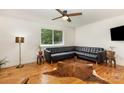 Cozy living room with hardwood floors, a large window, and comfortable black leather sectional sofa at 7015 Lavern St, Charlotte, NC 28215