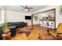 Comfortable living room with hardwood floors, ceiling fan, and leather furniture flowing into the kitchen at 7015 Lavern St, Charlotte, NC 28215