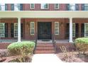 Stately brick home with a grand front porch and an elegant wrought-iron front door at 1009 Brookline Dr, Huntersville, NC 28078