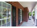 Stylish covered front porch featuring classic brickwork and sleek black shutters at 1009 Brookline Dr, Huntersville, NC 28078