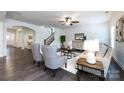 Living room featuring hardwood floors, white walls, gray chairs, area rug, ceiling fan, and a staircase at 10112 Andres Duany Dr, Huntersville, NC 28078