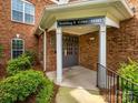 Building entrance with a covered entryway, painted columns, and a brick facade at 11530 Costigan Ln, Charlotte, NC 28277