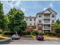 Exterior building shot with balconies, a well-manicured lawn, and a couple of vehicles parked out front at 11530 Costigan Ln, Charlotte, NC 28277