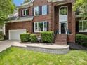Charming brick facade with a two-car garage, complemented by lush landscaping and a welcoming entrance at 11909 Cupworth Ct, Huntersville, NC 28078