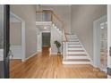 Inviting foyer with hardwood floors, a staircase, and neutral paint, creating a warm and welcoming atmosphere at 11909 Cupworth Ct, Huntersville, NC 28078