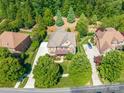 Overhead shot of a beautiful home surrounded by mature trees, a long driveway, and meticulously maintained lawns at 13056 Long Common Pkwy, Huntersville, NC 28078