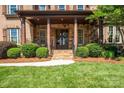 Stately brick home featuring a covered entrance, stone accents, and professionally landscaped front yard at 13056 Long Common Pkwy, Huntersville, NC 28078