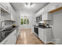 Bright kitchen featuring modern appliances, white cabinetry, and hardwood floors at 13446 Idlefield Ln, Matthews, NC 28105