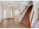 Welcoming entryway with tile floor, staircase, and entry to the living room with large bright windows at 15001 Rosemary Way Dr, Huntersville, NC 28078