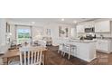 Open-concept living space with dining area, kitchen with island seating, and comfortable living room with large windows at 15031 Milo Ln, Charlotte, NC 28278