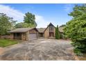 Charming stone house with a spacious driveway and a detached garage, nestled among mature trees at 1515 Heatherloch Dr, Gastonia, NC 28054