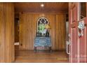 Cozy foyer featuring wood paneling, a decorative table, and an arched window, creating a warm welcome at 1515 Heatherloch Dr, Gastonia, NC 28054