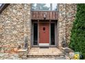 Inviting front entrance with a stone facade, decorative lanterns, and a colorful welcome mat at 1515 Heatherloch Dr, Gastonia, NC 28054