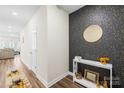 Elegant hallway featuring modern wallpaper, stylish decor, and hardwood flooring at 1563 Old Rivers Rd, Concord, NC 28027
