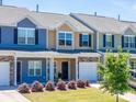 Street view of townhomes featuring manicured lawns, colorful exteriors, and attached garages at 16039 Simril Ct, Charlotte, NC 28278