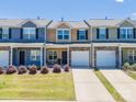 Shot of townhomes featuring manicured lawns, colorful exteriors, and attached garages at 16039 Simril Ct, Charlotte, NC 28278