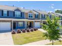 Street view of townhomes featuring manicured lawns, colorful exteriors, and attached garages at 16039 Simril Ct, Charlotte, NC 28278