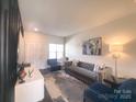 Cozy living room with a neutral color palette, tufted sofa, stylish rug, and unique decor pieces at 16039 Simril Ct, Charlotte, NC 28278