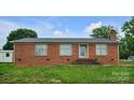 Charming single-story brick home featuring a well-maintained lawn and a detached storage shed at 1609 Mcfarland Dr, Shelby, NC 28152