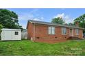 Charming single-story brick home featuring a well-maintained lawn and a detached storage shed at 1609 Mcfarland Dr, Shelby, NC 28152