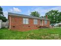 Charming single-story brick home featuring a well-maintained lawn and a detached storage shed at 1609 Mcfarland Dr, Shelby, NC 28152