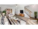 Bright living room with modern furnishings, stylish rug, ceiling fan, and staircase at 1908 Harvest Ln # 5, Charlotte, NC 28210