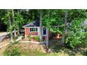 Charming brick home featuring a cheerful blue door framed by mature trees and a well-manicured lawn at 1936 Russell Ave, Charlotte, NC 28216