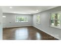 Bright living room with refinished hardwood floors and an abundance of natural light shining through multiple windows at 1936 Russell Ave, Charlotte, NC 28216
