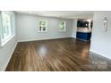 Spacious living room featuring refinished hardwood floors, fresh paint, and natural light from large windows at 1936 Russell Ave, Charlotte, NC 28216