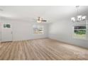 Bright living room with light wood flooring, a ceiling fan, a chandelier, and abundant natural light through windows at 208 N Correll St, Landis, NC 28025