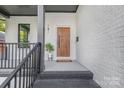 Charming front porch with painted brick, stylish wooden front door, and welcoming decor at 2414 E 7Th St, Charlotte, NC 28204