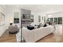 Bright living room features a modern fireplace, plush seating, and hardwood floors at 2414 E 7Th St, Charlotte, NC 28204