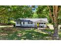 Picturesque home surrounded by lush trees and landscaping offering great curb appeal and a welcoming porch at 2903 Price Rushing Rd, Monroe, NC 28110