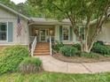 Inviting front entrance with brick steps, a white railing, and lush greenery at 2911 Butter Churn Ln, Matthews, NC 28105