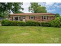 Inviting brick home featuring a well-kept lawn and neatly trimmed bushes, providing pleasant curb appeal at 3424 Autumn Dr, Gastonia, NC 28056