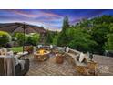 Backyard stone patio features a fire pit and built in bench seating, perfect for outdoor entertaining at 4430 Bravery Sw Pl, Concord, NC 28027