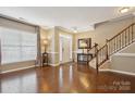 Bright foyer featuring hardwood floors, an elegant staircase, and a front door at 4430 Bravery Sw Pl, Concord, NC 28027