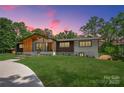 Beautiful home featuring a well-manicured lawn and a charming facade, perfect for modern living amidst a natural setting at 5033 Waxhaw Indian Trail Rd, Matthews, NC 28104