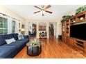 Inviting living room featuring hardwood floors, a ceiling fan, and custom built-in shelving at 530 Shady Oaks Dr, Stanley, NC 28164
