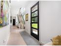 Bright foyer with wood floors, modern staircase, and sleek front door with sidelights at 5925 Creola Rd, Charlotte, NC 28270