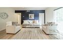 A cozy living room featuring a navy accent wall with white sofas and a woven rug at 5927 Quail Hollow Rd # H, Charlotte, NC 28210
