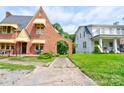 View of a charming brick Tudor-style home with arched entryway and adjacent property at 611 E Marion St, Shelby, NC 28150