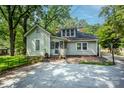 Back exterior showing a backyard with a brick patio and mature trees at 636 N Center St, Statesville, NC 28677