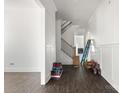 Hallway with wood floors leading to staircase and open floorplan at 6782 Kingfisher Ct, Denver, NC 28037