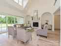 Bright living room with a fireplace, high ceilings, and large windows overlooking the backyard at 7209 Alexander Rd # 3, Charlotte, NC 28270