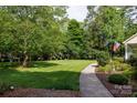 Exterior view of a well-maintained lawn, lush trees, walkway, landscaping and charming home in a desirable neighborhood at 785 Sanside Dr, York, SC 29745
