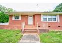 Classic brick home featuring a welcoming front entrance with steps, railings, and a storm door at 800 Charles Rd, Shelby, NC 28150