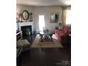 Cozy living room featuring a fireplace, hardwood floors, and natural light at 8039 Scarlet Oak Ter, Fort Mill, SC 29707