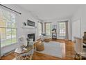 Spacious living room with a fireplace, multiple windows and hardwood flooring at 8441 Sandowne Ln, Huntersville, NC 28078