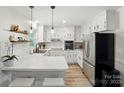 Modern white kitchen with stainless steel appliances, quartz countertops, and ample cabinet space at 103 W Sunset Dr, Locust, NC 28097